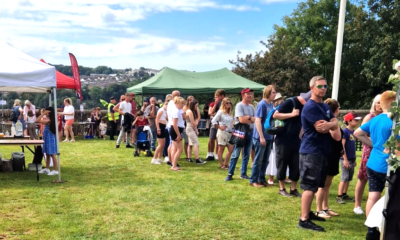 Group of people forming a queue  alongside gazebos at Chudleigh Picnic in 2023